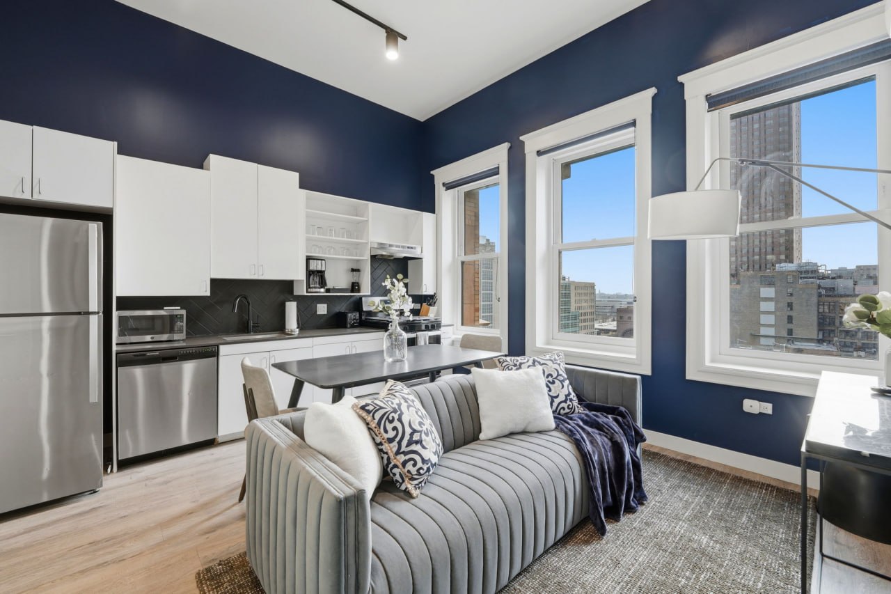Navy blue open kitchen and living area with full appliances and city view