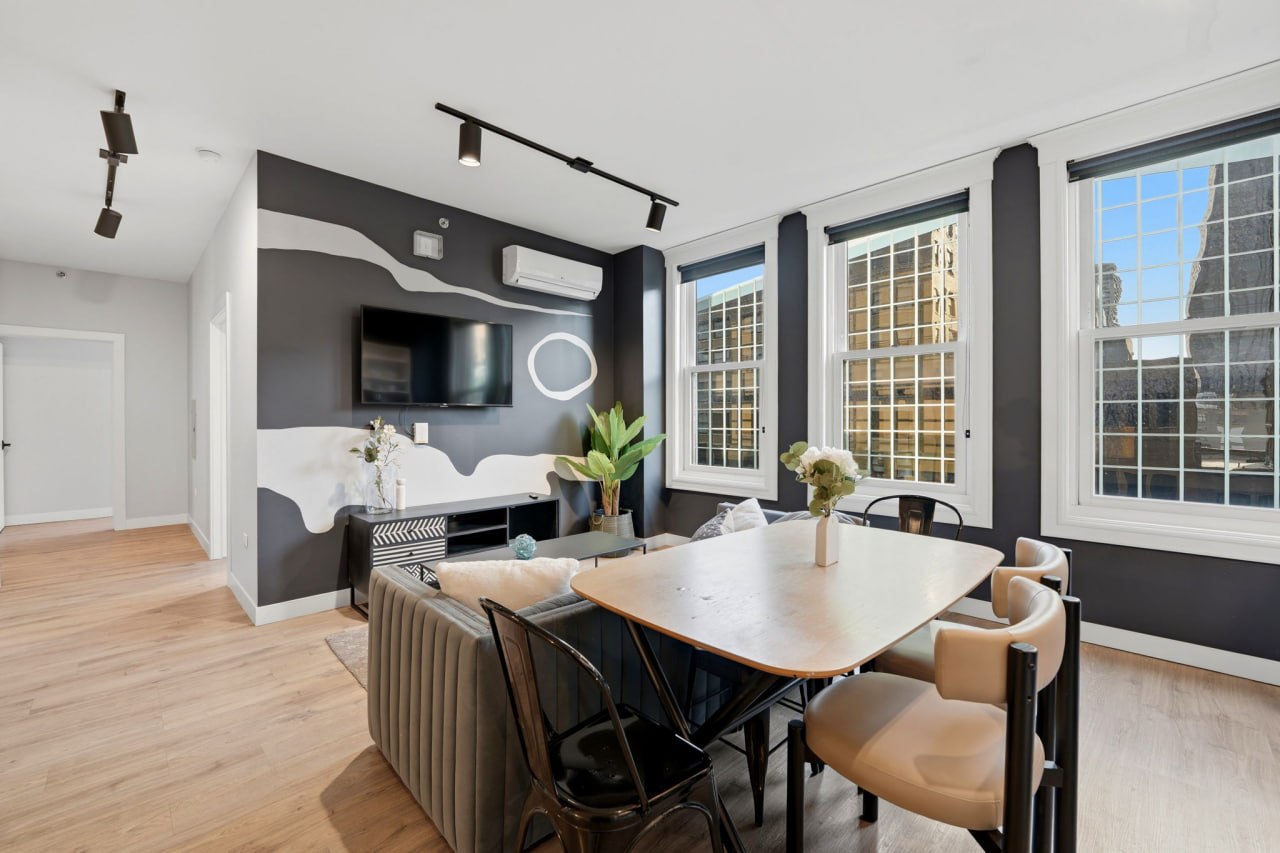 Dark charcoal mural living room with large windows and city views