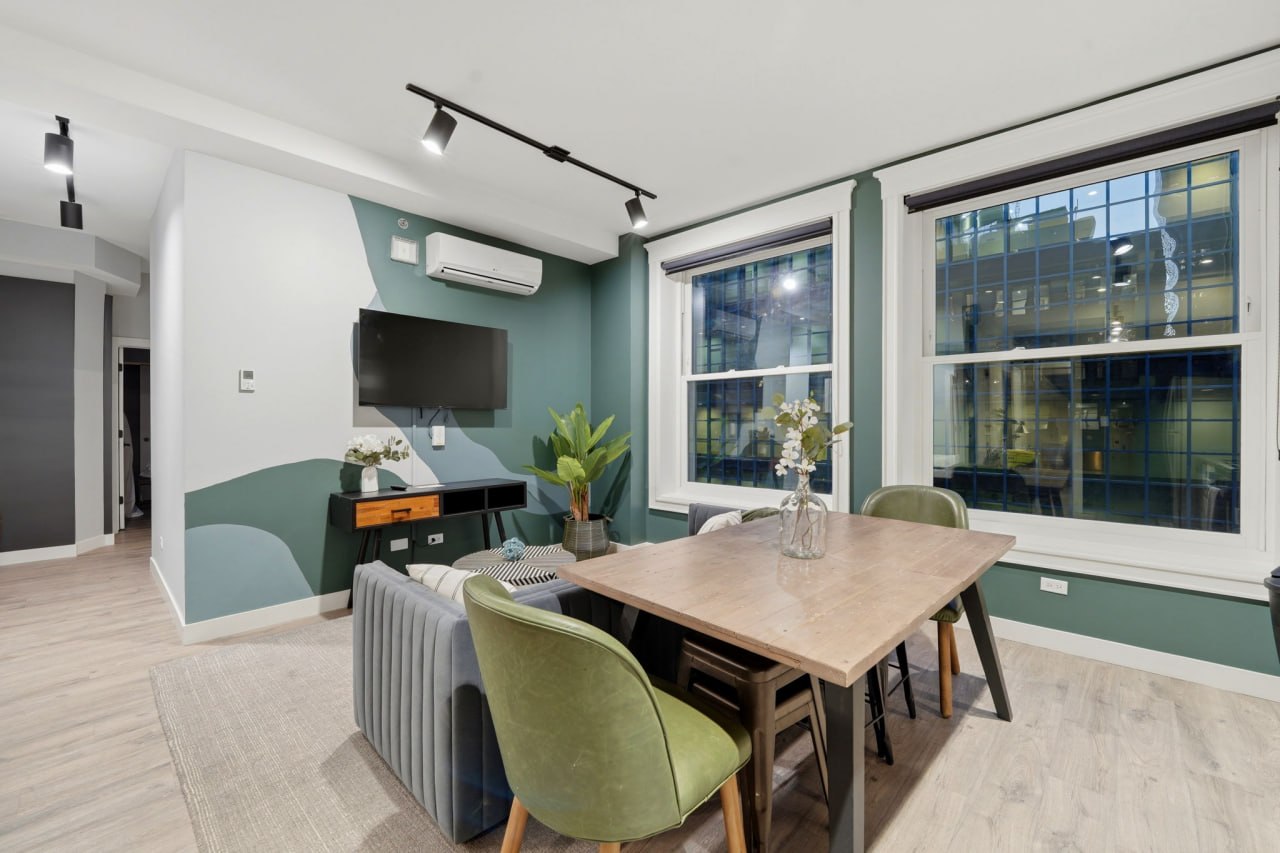 Green accent wall suite with dining table and city views