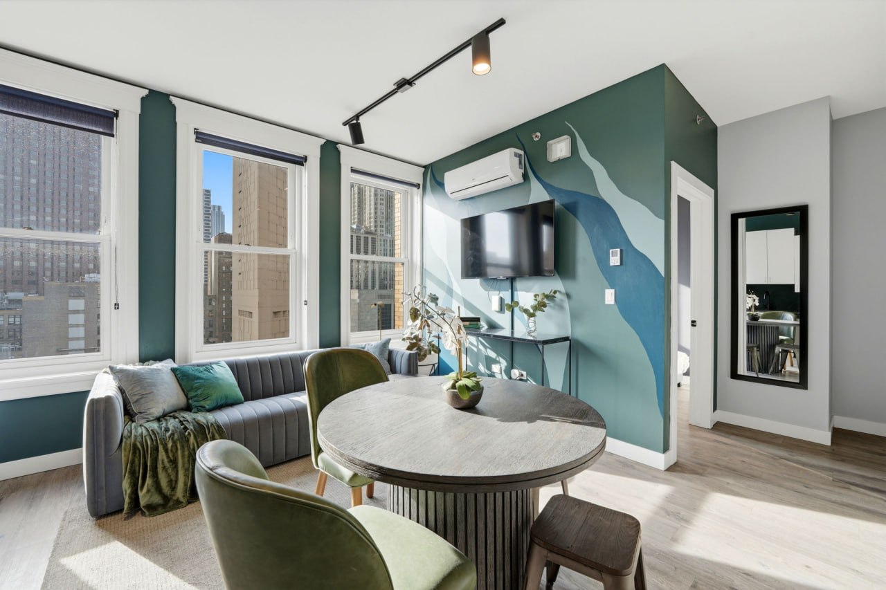 Teal green mural wall living room with dining table and city views