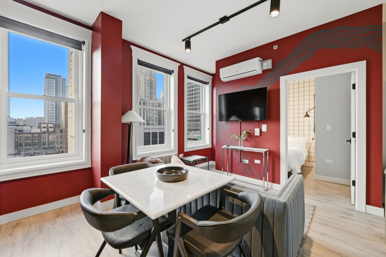 Red accent wall living and dining room with city views